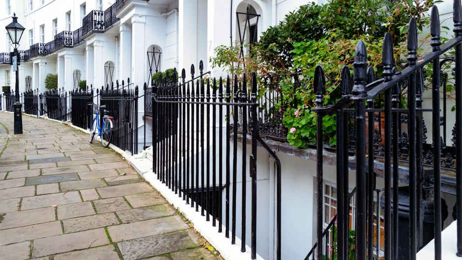 Elegant white Regency townhouse with black iron railings on a period street